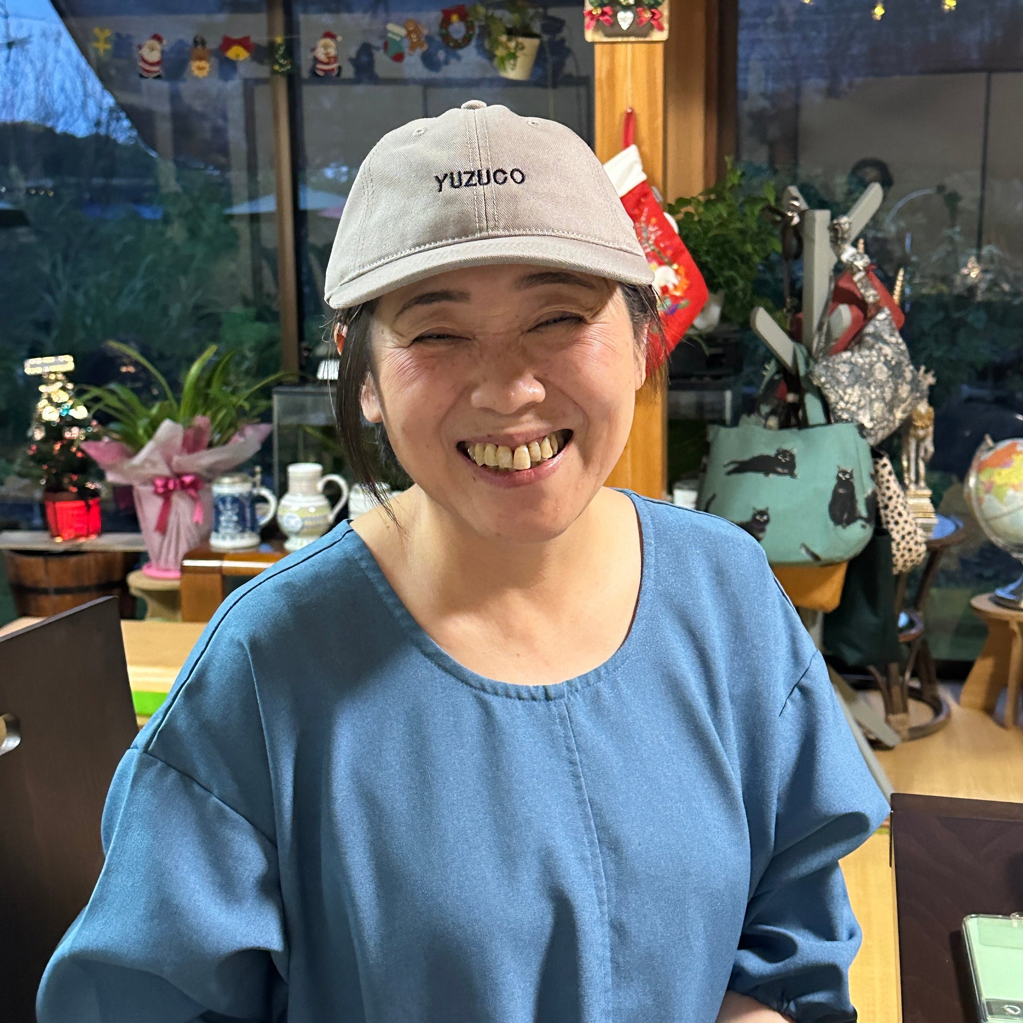 Kamiya Yoshie AKA Madame Yuzu wearing a YUZUCO hat in a coffee shop in Oita prefecture